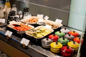 A buffet with various food items and condiments.