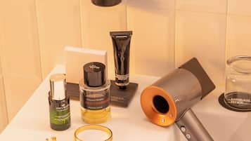 A bathroom vanity with toiletries and a hairdryer.