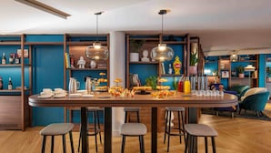 A modern kitchen with a central island, bar stools, and a variety of kitchenware and decorative items. - Urban Hive Milano (Milan)