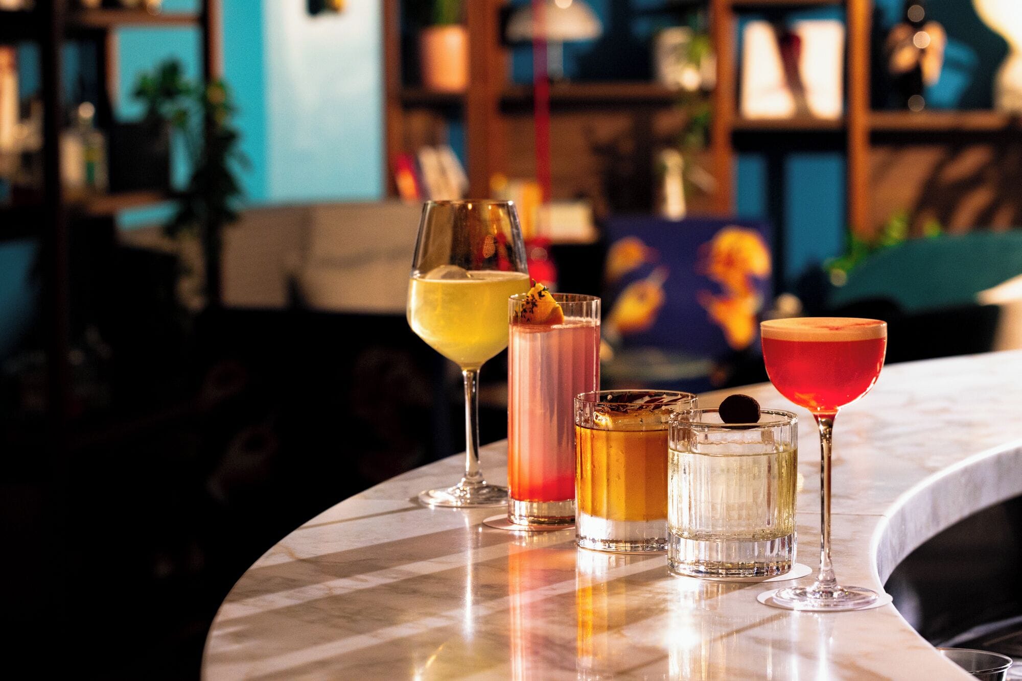 A bar area with various drinks in glasses.