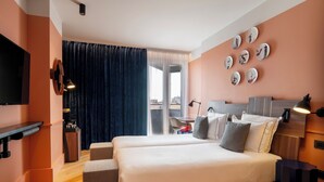 A hotel room with a bed, bedside tables, a desk, a chair, a TV, and a large window with curtains. - Urban Hive Milano (Milan)