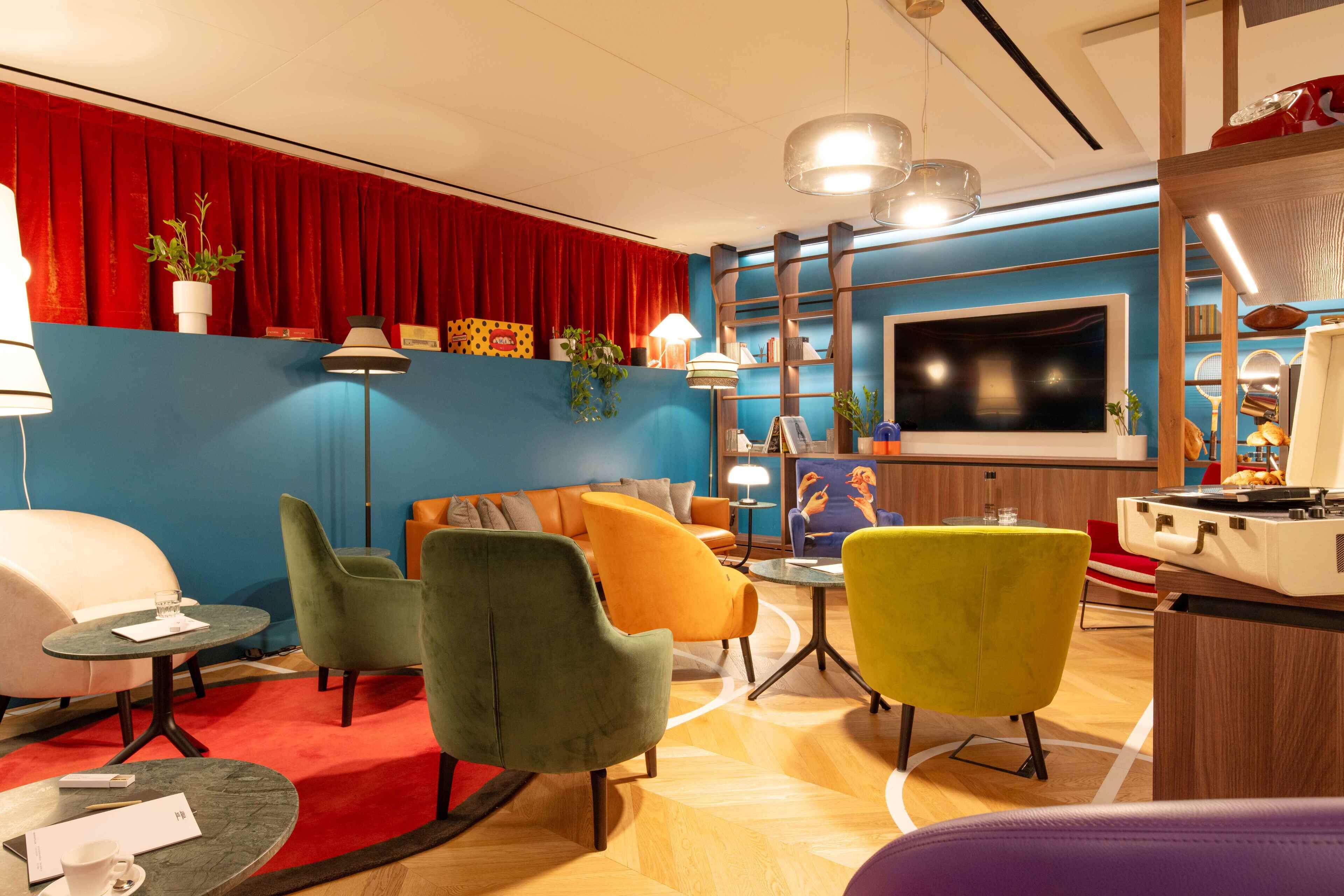 Una sala de estar moderna con una cortina roja, un televisor de pantalla plana y un juke box.