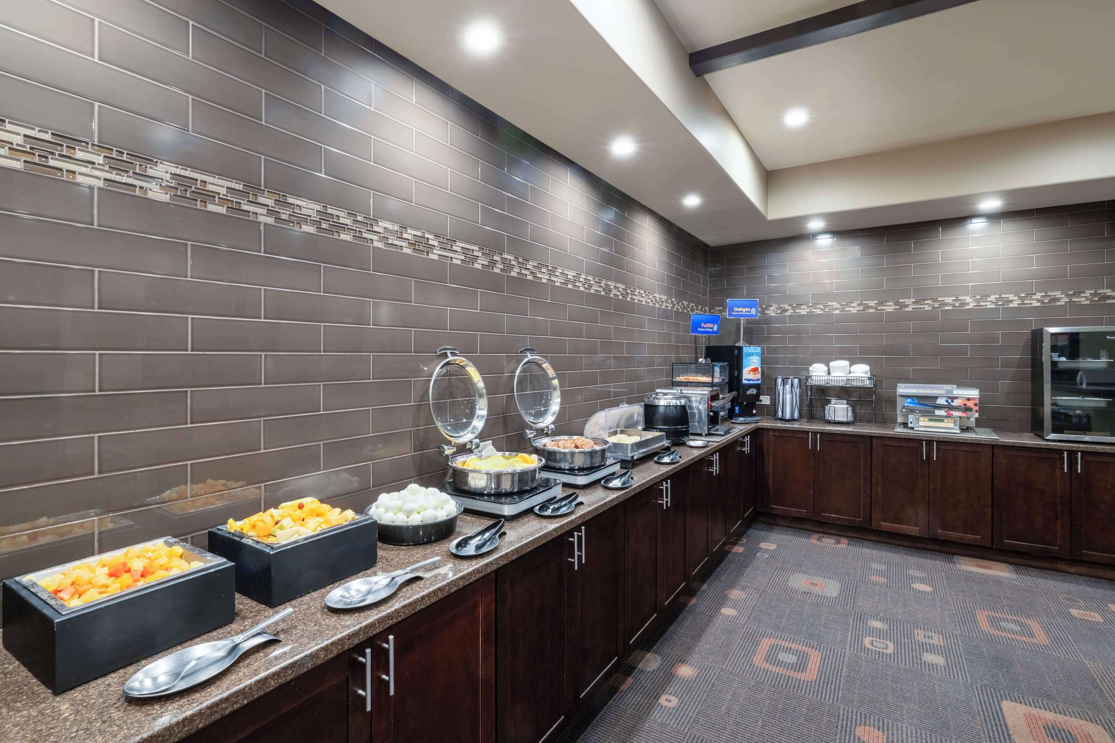 Een hotelkeuken met een buffetopstelling, inclusief diverse voedselcontainers en bestek.