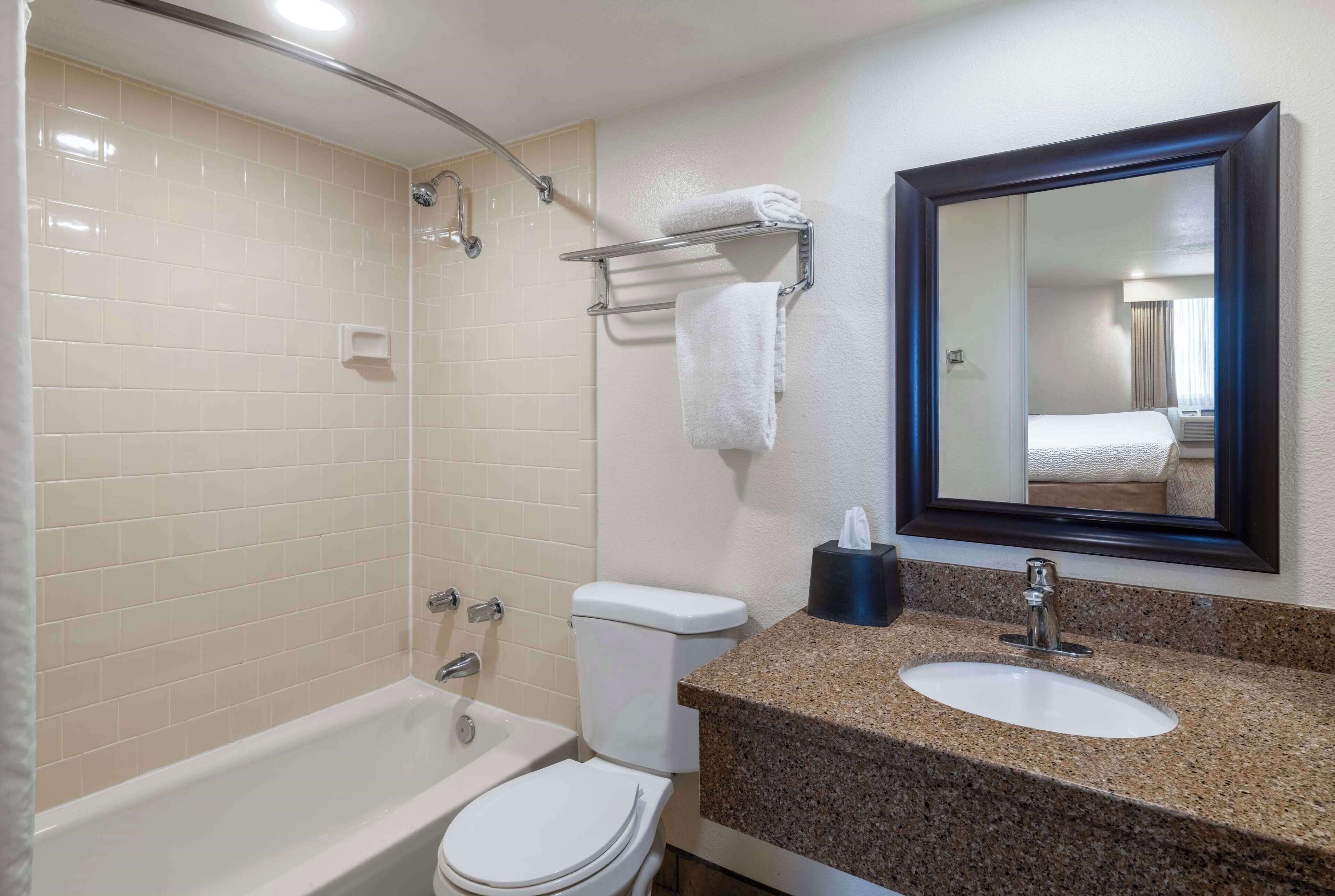 A bathroom with a bathtub, toilet, and sink.