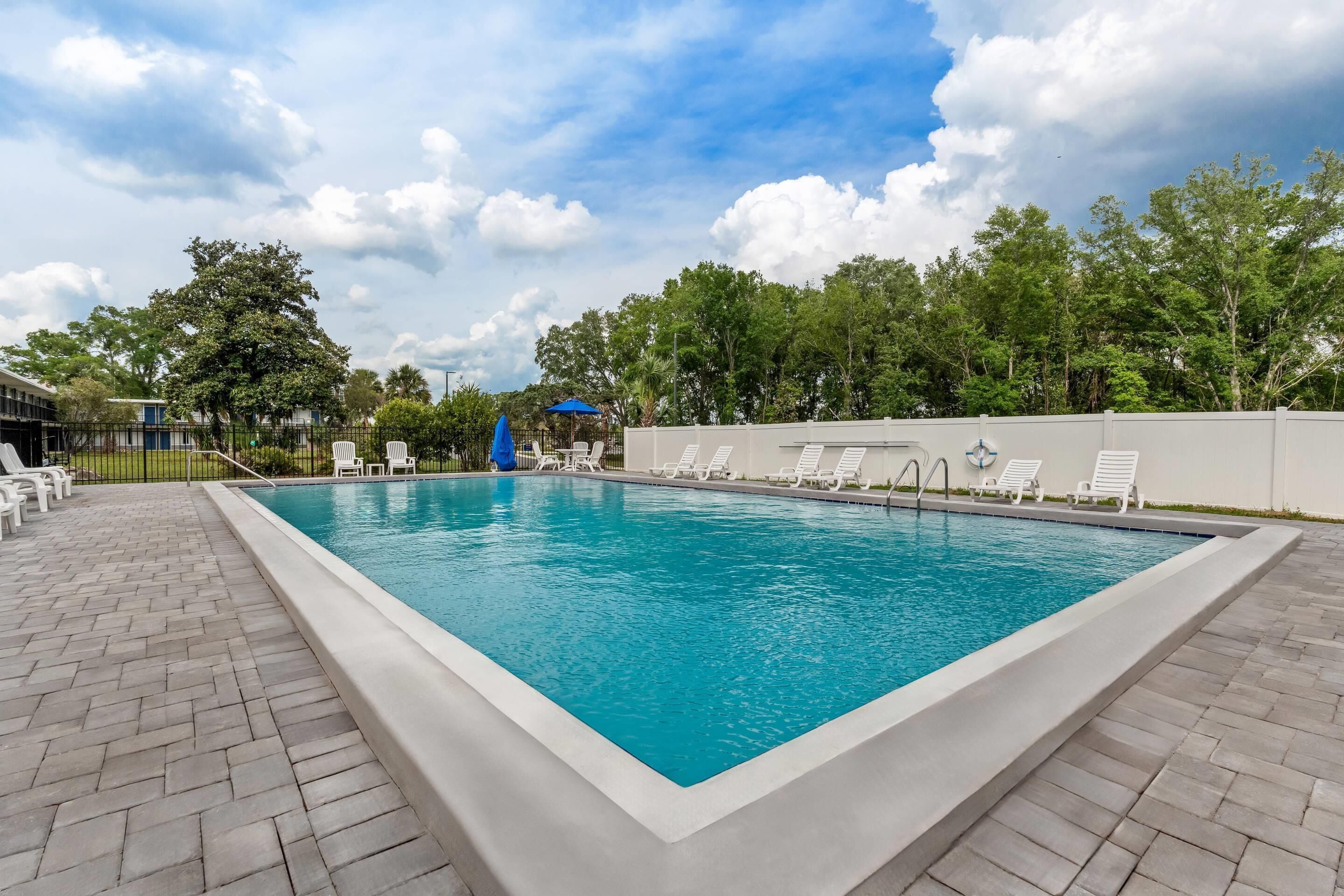 Una piscina al aire libre de temporada, sombrillas