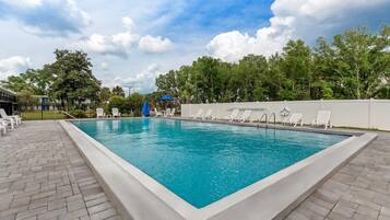 Una piscina al aire libre de temporada, sombrillas