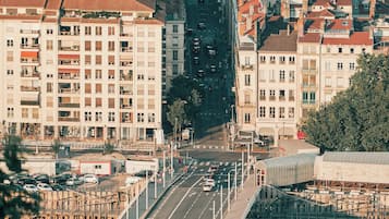 Un paisaje urbano con un puente destacado, edificios con tejados rojos y un río.
