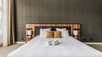Ein Hotelzimmer mit einem großen Bett, zwei Nachttischen, einer Kopfteil und einer Wand mit Muster.