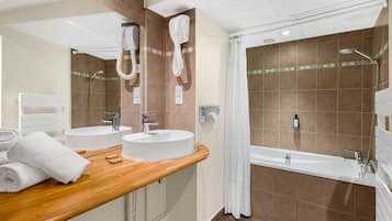A bathroom with two sinks, a shower, and a bathtub.
