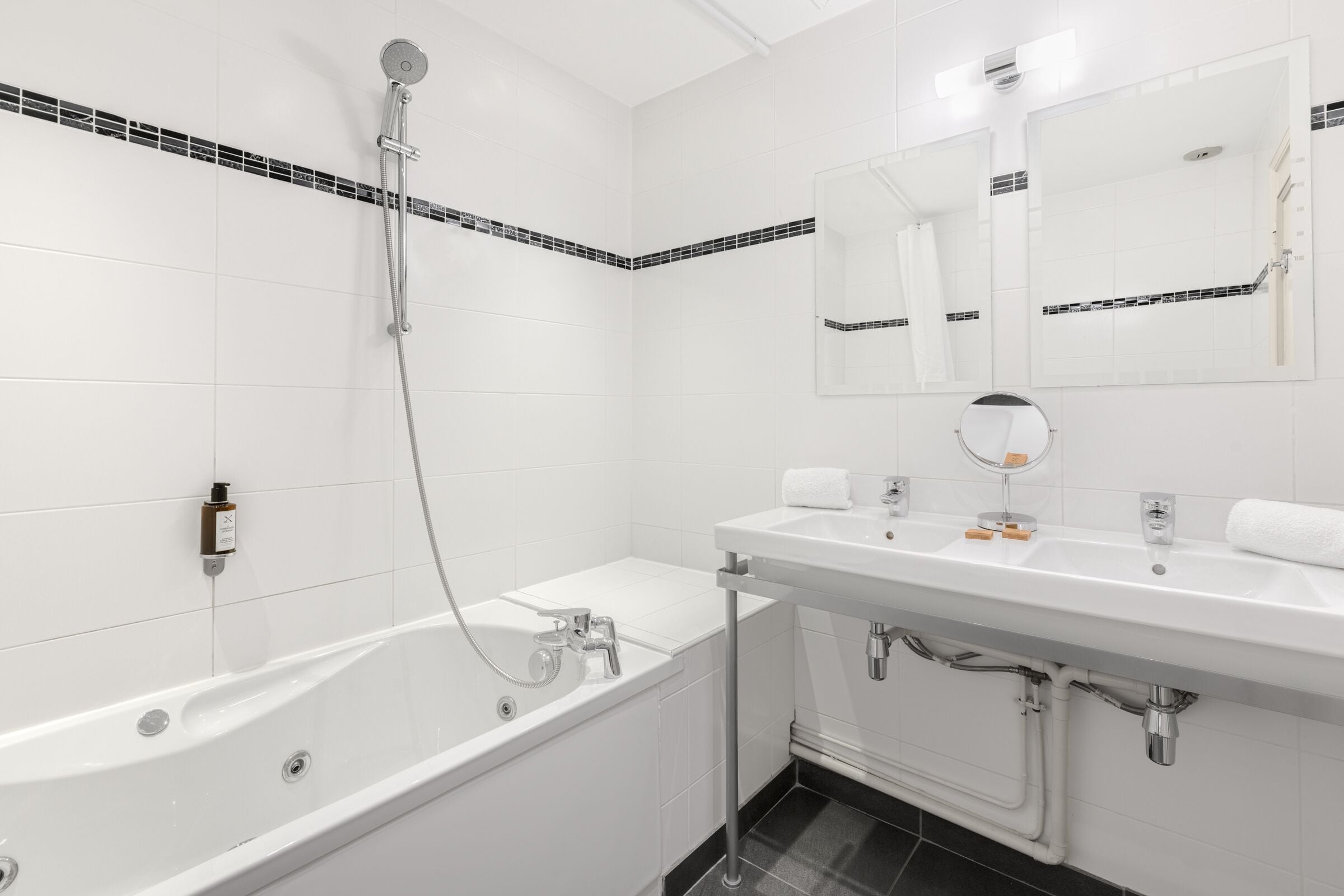 A modern bathroom with a bathtub, a sink, and a mirror.