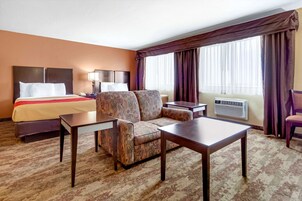 Une chambre d’hôtel avec un lit, un canapé, une table et un bureau.