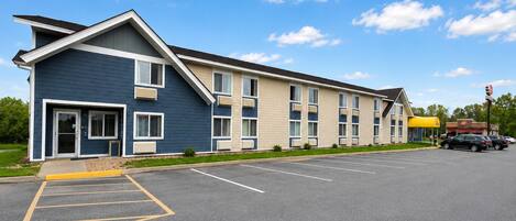 A multi-story hotel with a parking lot in front.