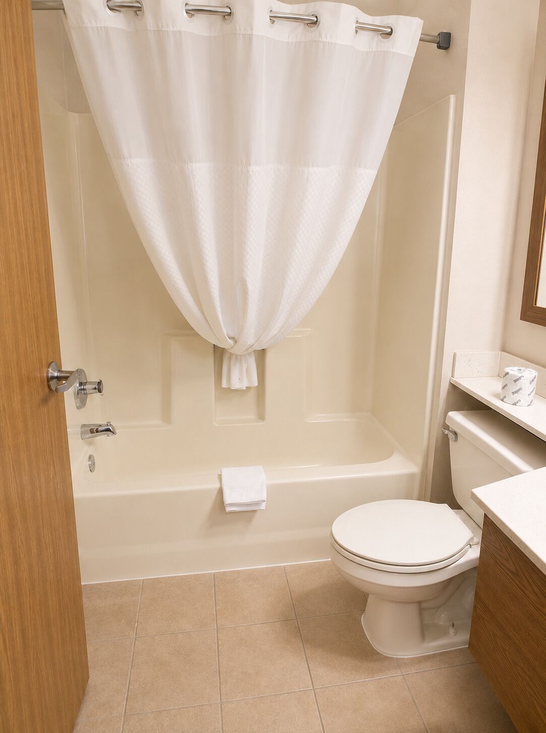 A bathroom with a bathtub, toilet, and a shower curtain.