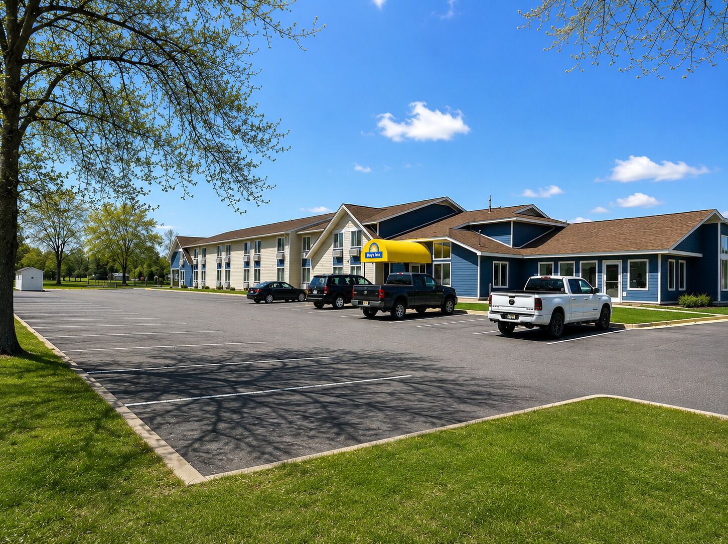 A motel with a parking lot, a gas station, and a building with a blue exterior.