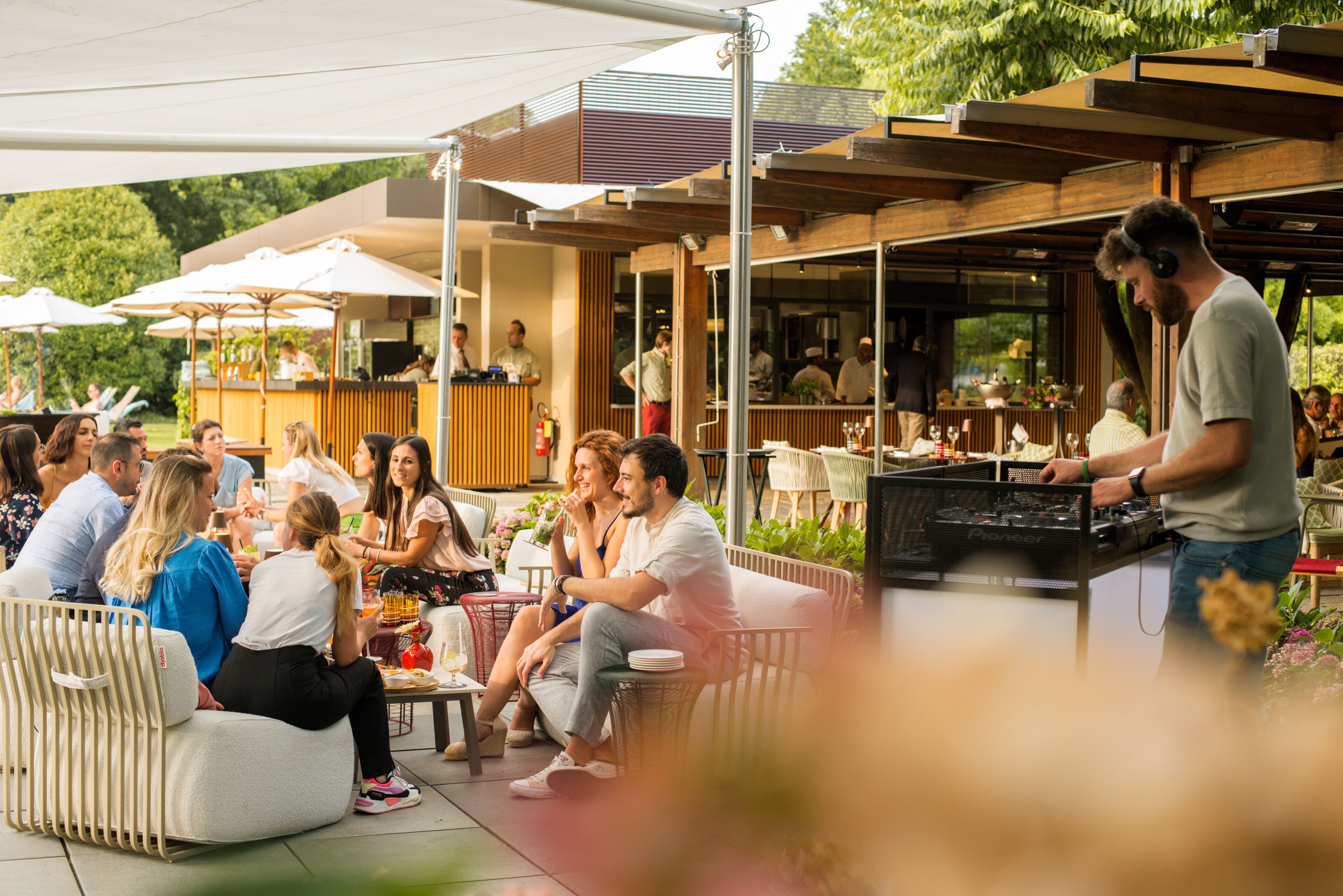 An outdoor dining area with a DJ booth, tables, and chairs.