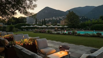 Un espace extérieur aménagé avec des sièges, une piscine et des montagnes en arrière-plan.