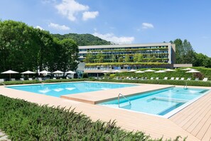 Una piscina techada, una piscina al aire libre de temporada, sombrillas