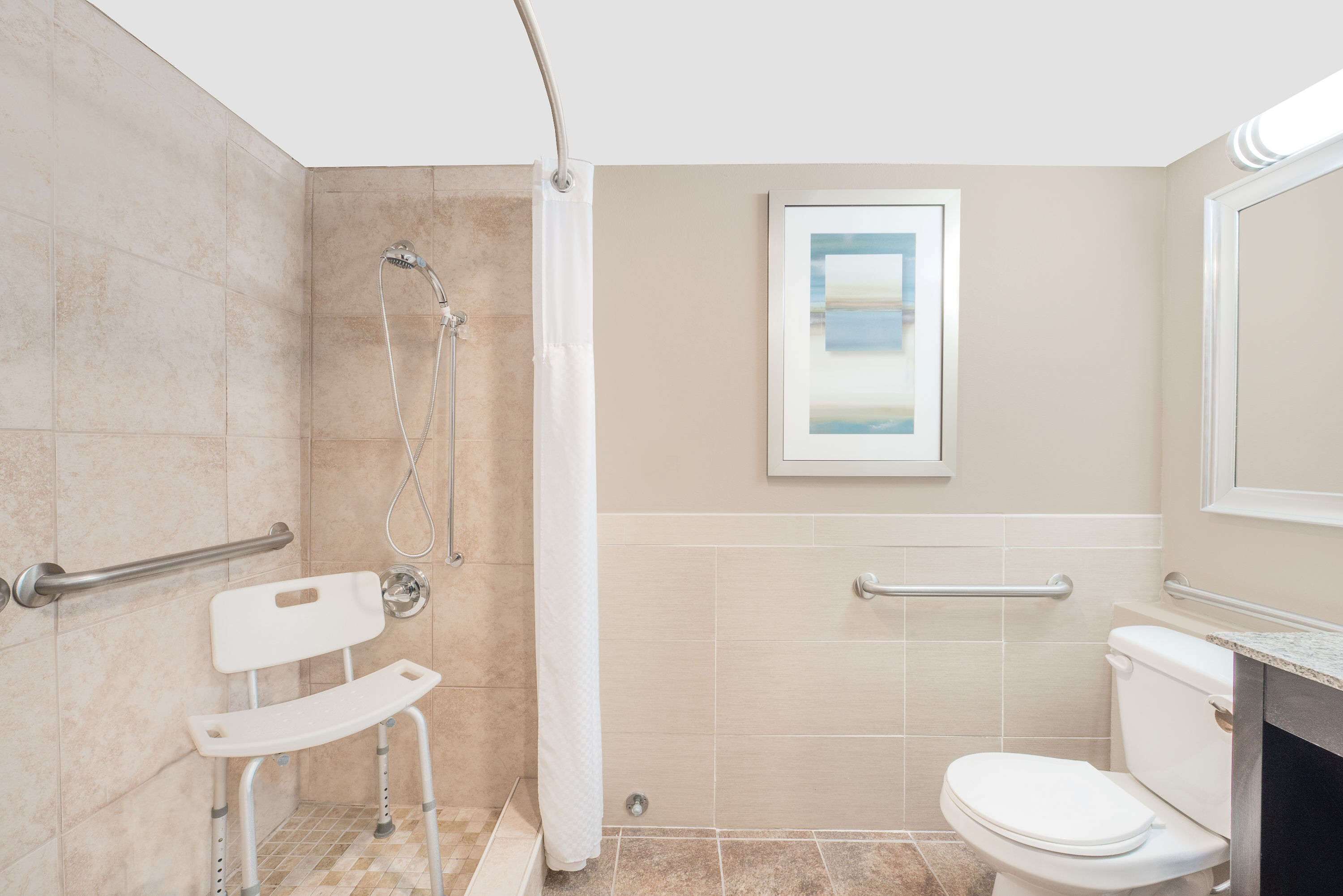 A bathroom with a shower, toilet, and a window.