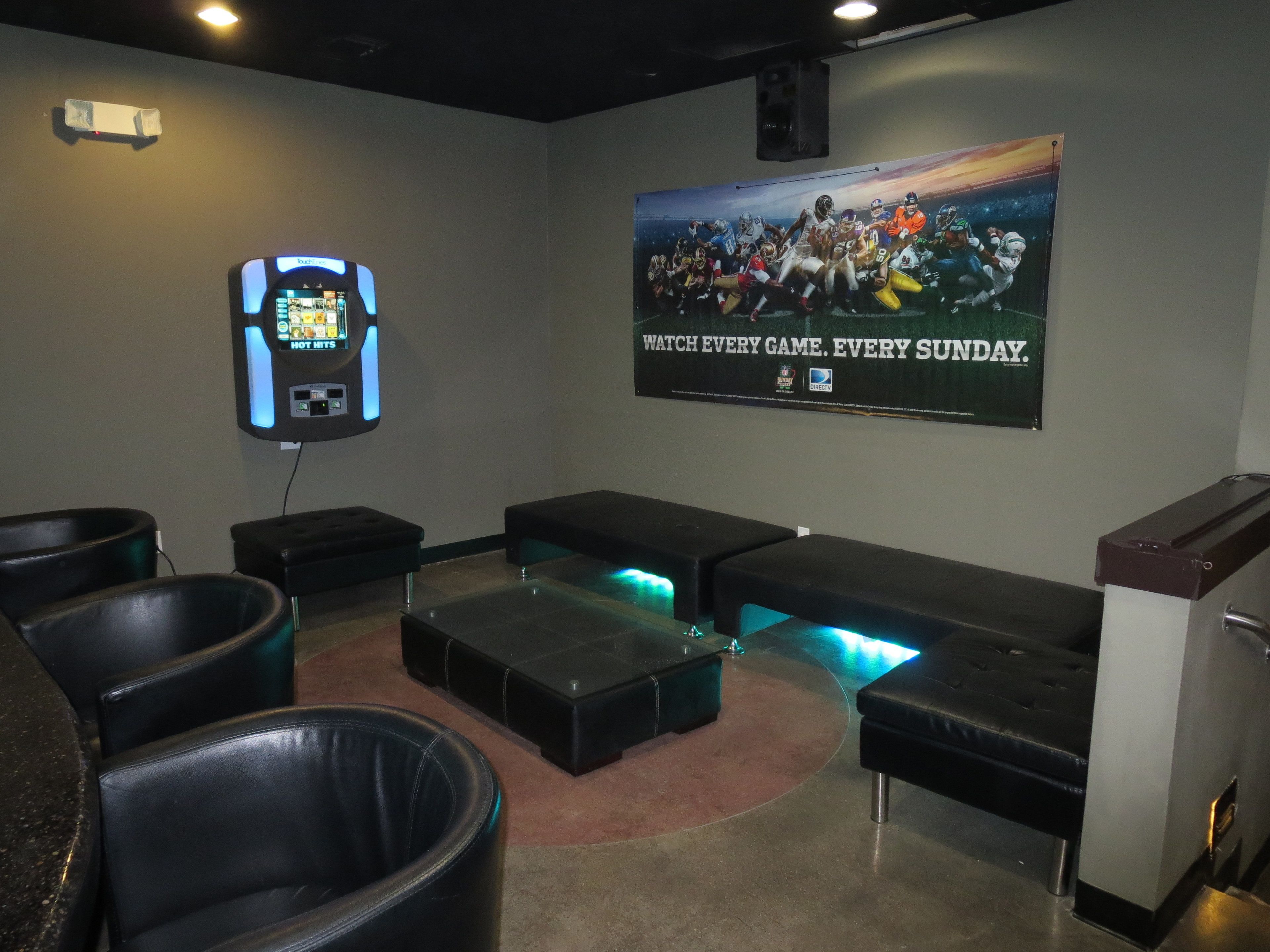 A home theater room with a large screen, comfortable seating, and a sound system.
