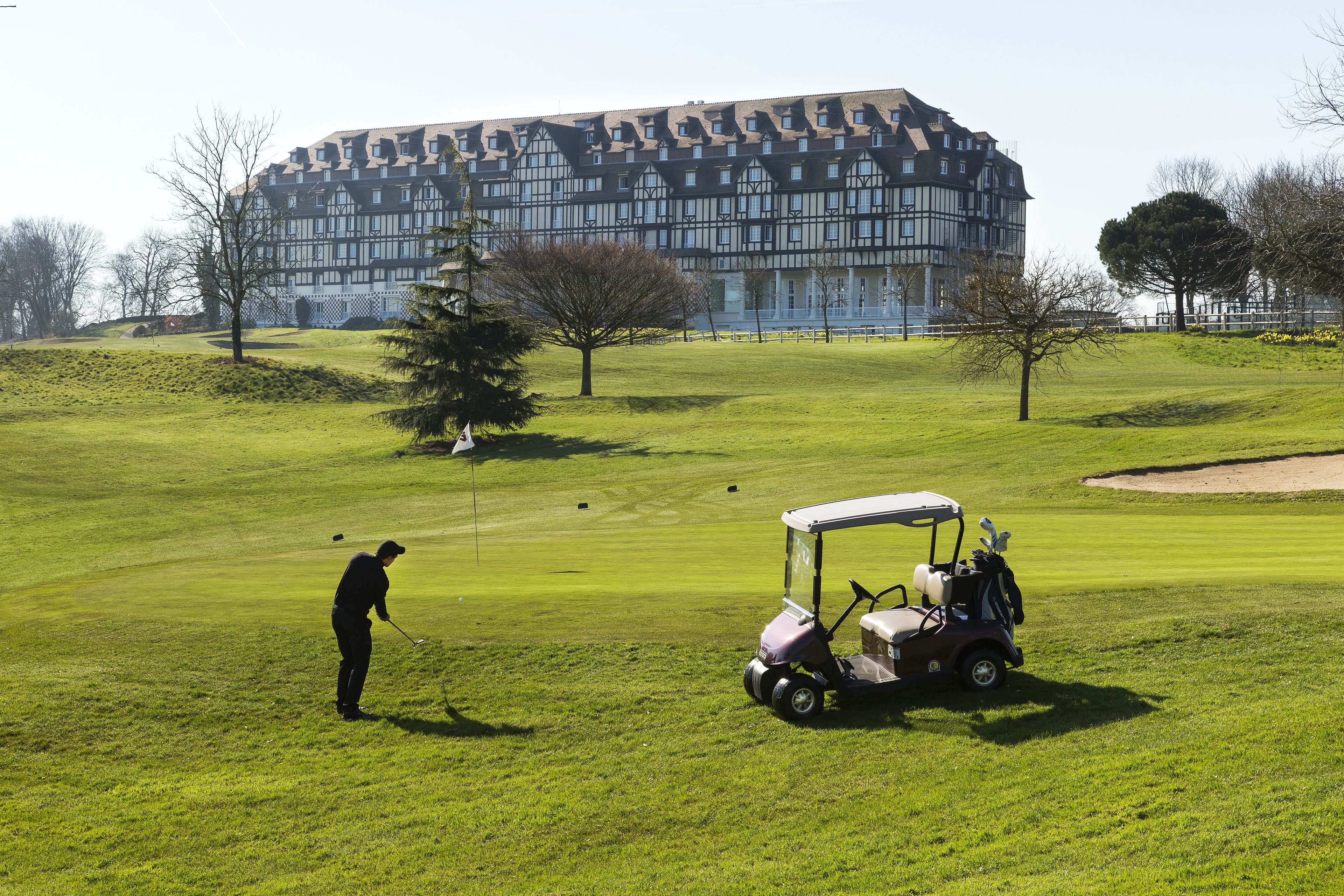 A golf course with a large building in the background.