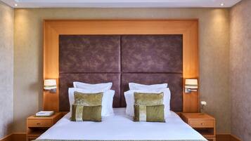 A hotel room with a large bed, two nightstands, and a wooden headboard.