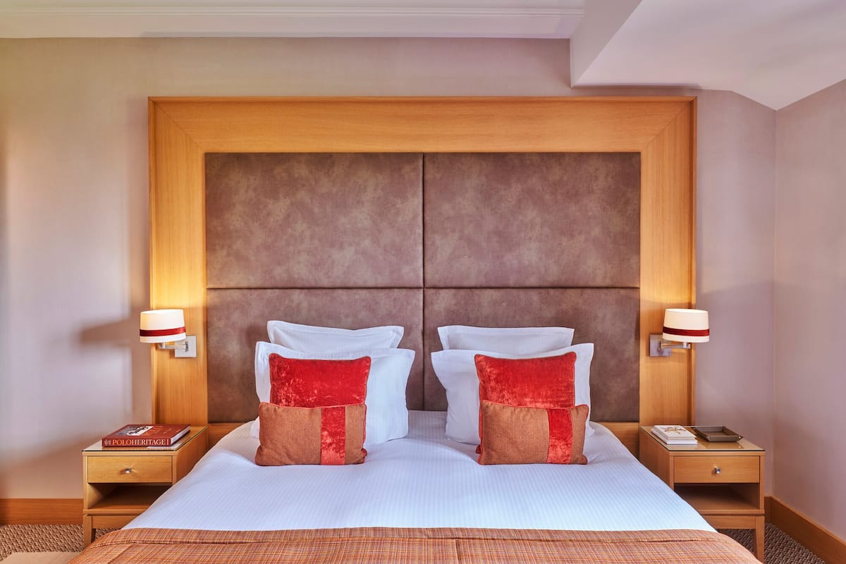 Ein Hotelzimmer mit einem großen Bett, zwei Nachttischen und einem Holzkopfende.