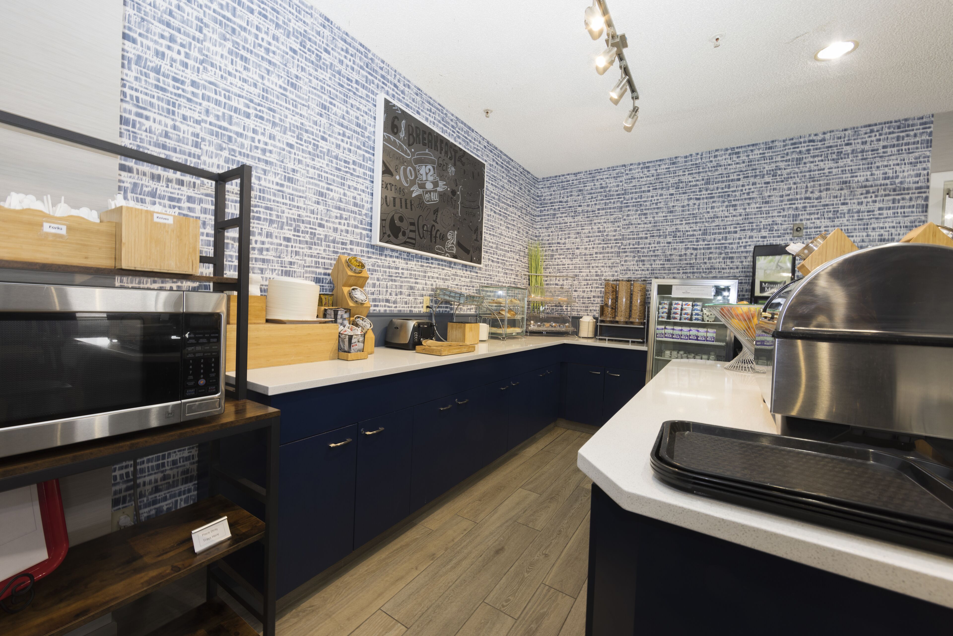 Una cocina moderna con salpicadero de diseño azul, electrodomésticos de acero inoxidable y armarios de madera.