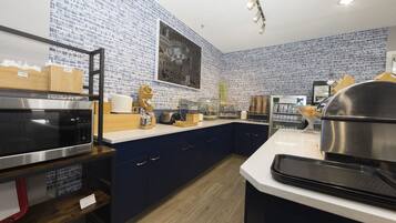 Una cocina moderna con salpicadero de diseño azul, electrodomésticos de acero inoxidable y armarios de madera.