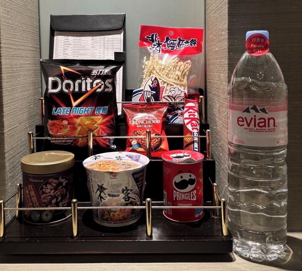 A snack and drink display with items like Doritos, Pringles, and Evian water.