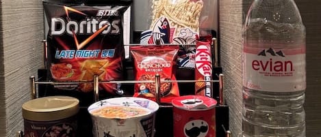 A snack and drink display with items like Doritos, Pringles, and Evian water.