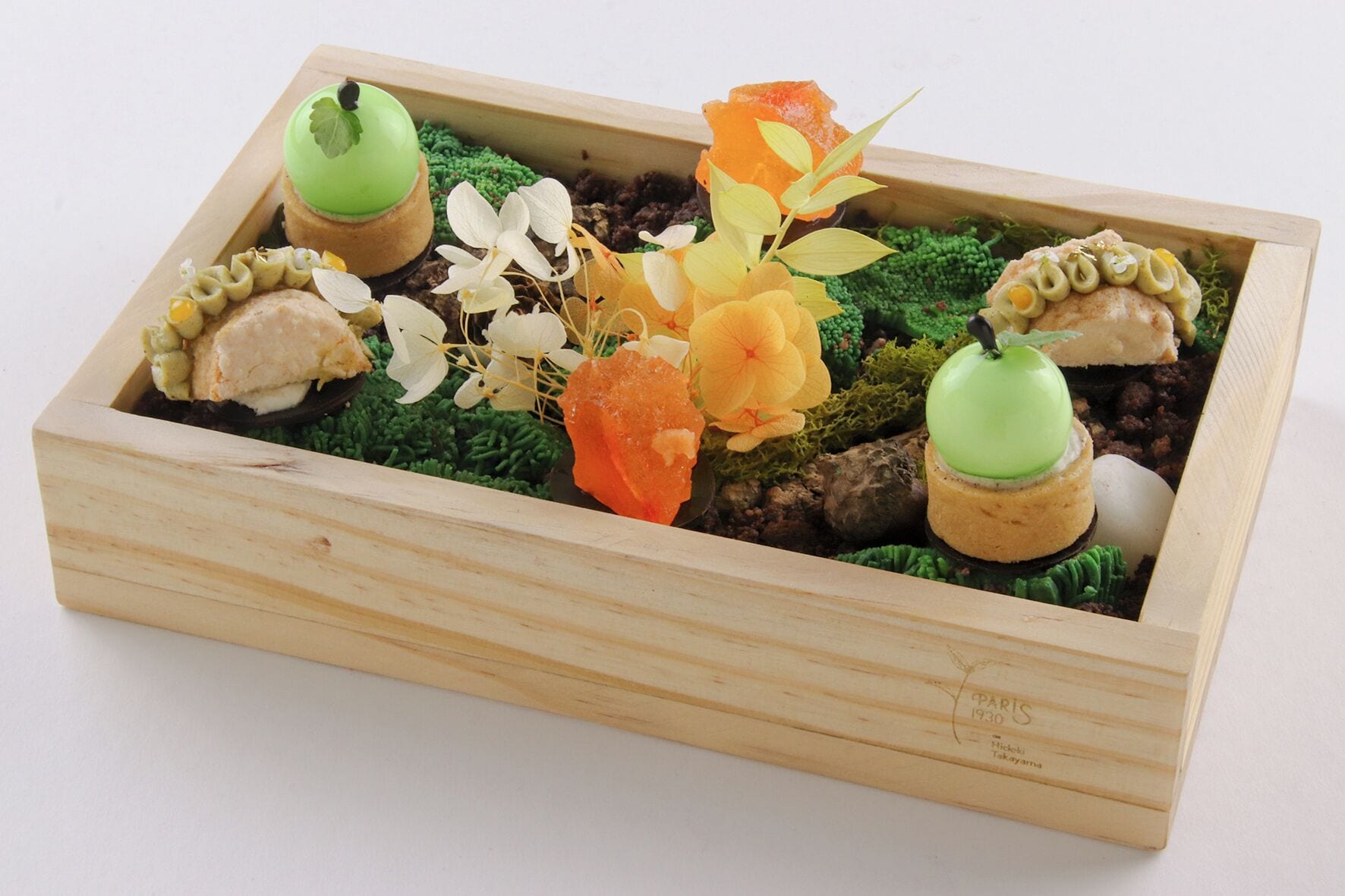 A wooden box containing various food items and decorative elements.
