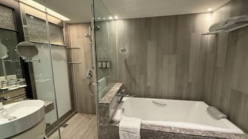 A modern bathroom with a glass-enclosed shower, a standalone bathtub, and a vanity with a sink.