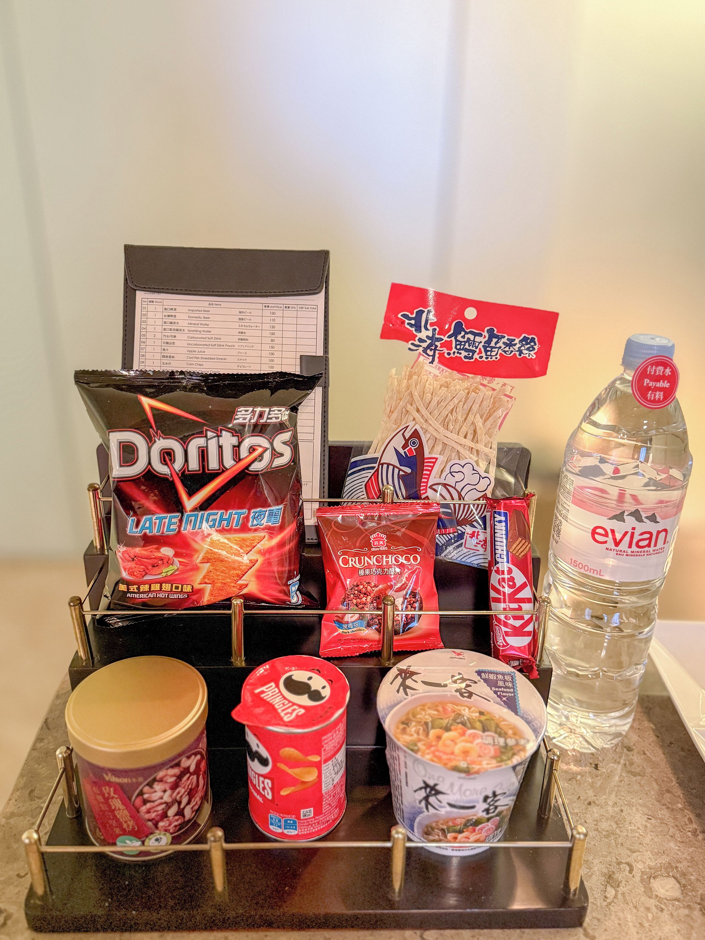 A snack display with various items including Doritos, Crunchy Oatmeal, and a bottle of Evian water.