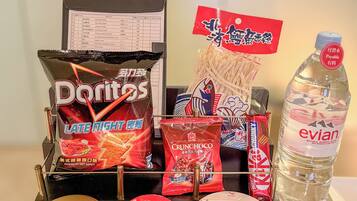 A snack display with various items including Doritos, Crunchy Oatmeal, and a bottle of Evian water.