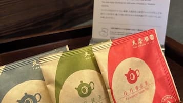 A tray with three tea packages labeled Tieguyin Oolong Tea, Jasmine Green Tea, and Taiwanese Assam Tea.