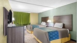 A hotel room with two beds, a desk, a TV, and a green curtain.
