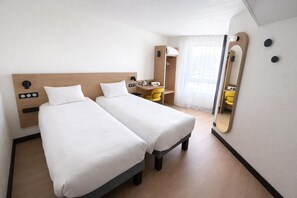 A hotel room with two single beds, a desk, a chair, a mirror, and a wardrobe. - B&B Hotel Orléans Centre Foch (Orléans)