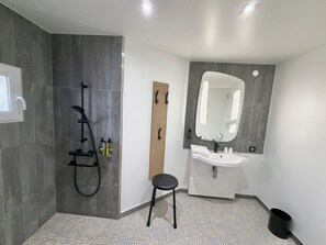 A modern bathroom with a shower, sink, and mirror. - B&B Hotel Orléans Centre Foch (Orléans)