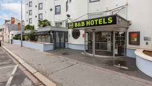 A B&B hotel with a glass entrance, a sign above the door, and a white building with multiple windows. - B&B Hotel Orléans Centre Foch (Orléans)