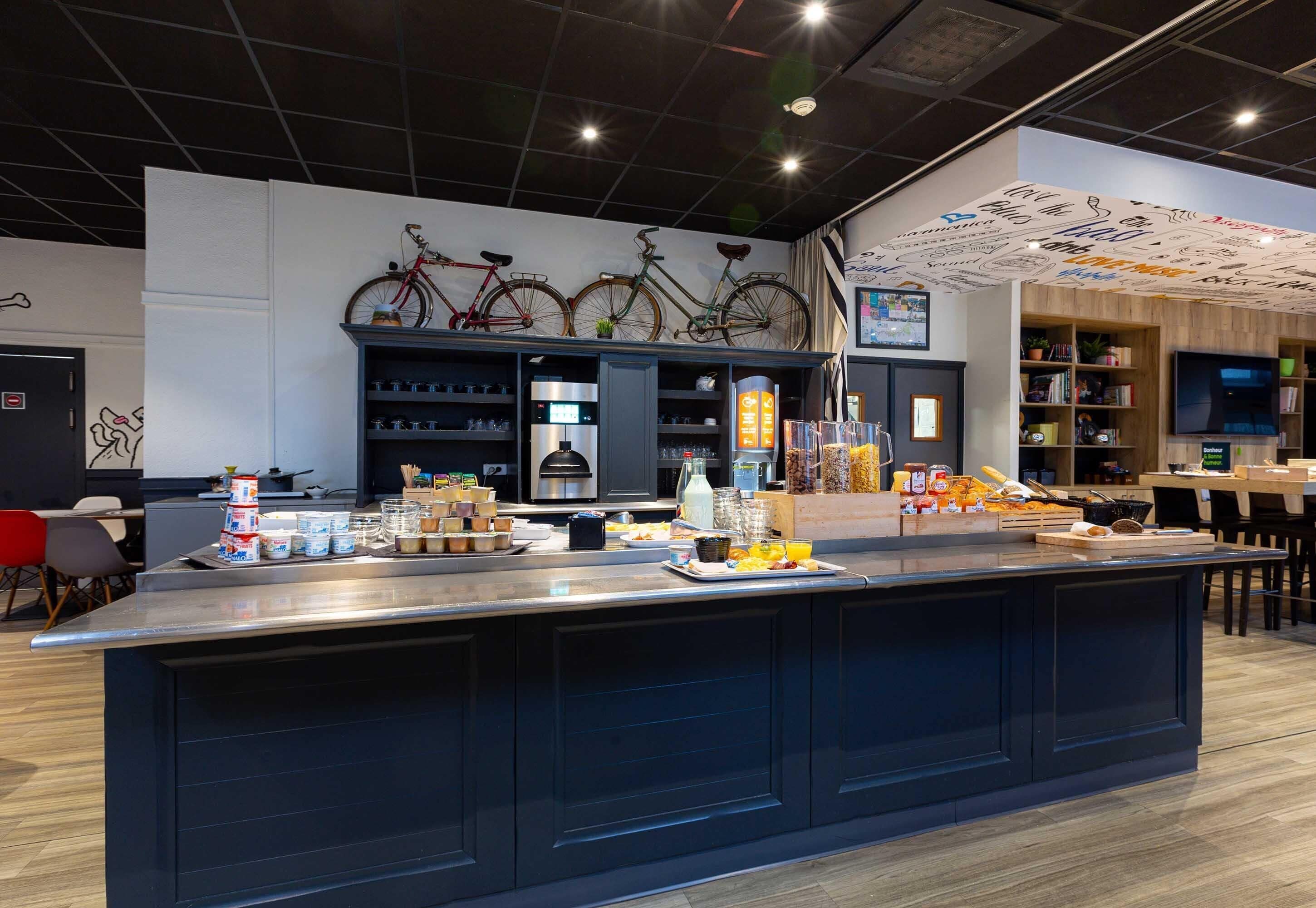 A modern kitchen area with a central island, various food items, and bicycles mounted on the wall.