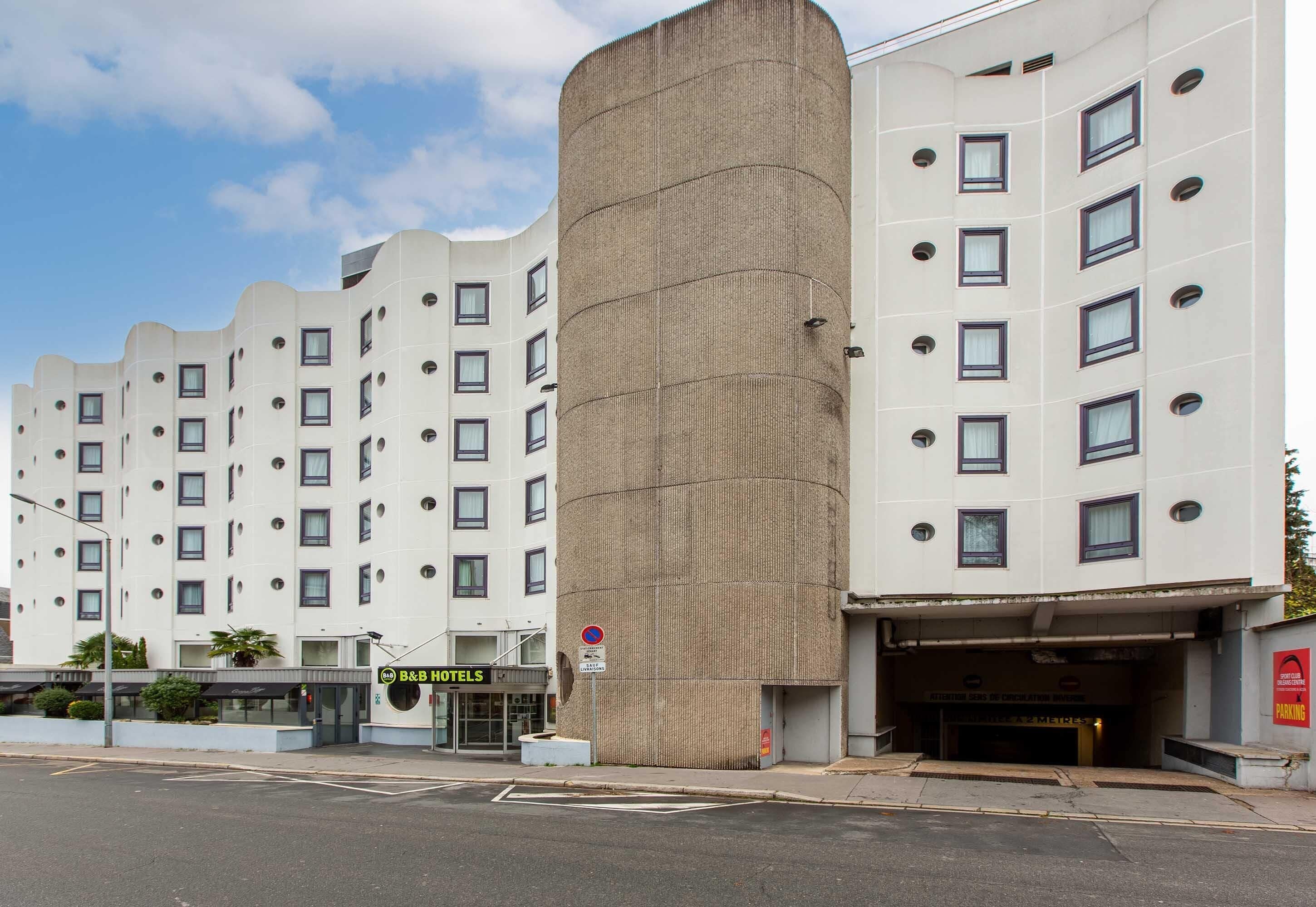 Ein modernes Hotel mit einem einzigartigen zylindrischen Zentralturm, mehreren Stockwerken und einem Zugang zur Tiefgarage.