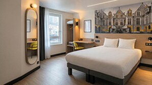 A hotel room with a large bed, a desk, a chair, a mirror, and a cityscape mural on the wall. - B&B Hotel Orléans Centre Foch (Orléans)