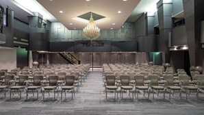 A conference room with rows of chairs, a chandelier, and a sign reading "TSPEULD". - Bilderberg Hotel 't Speulderbos (Garderen)