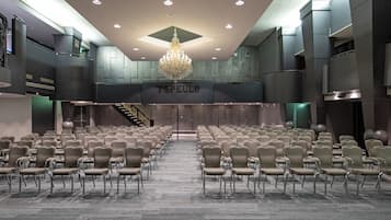 Ein Konferenzraum mit Stuhlreihen, einem Chandelier und einem Schild mit der Aufschrift 'TSPEULD'.