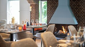 Comedor con pared de ladrillo, chimenea y mesa lista para una comida.