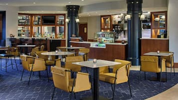 A bar area with seating, a television, and a variety of beverages.
