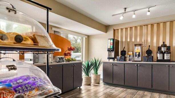 Cocina moderna con encimera de madera, estación de café y exhibición de alimentos.
