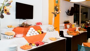 A buffet setup with various food items and a television mounted on the wall. - Hotel del Angel Reforma (Mexico City)