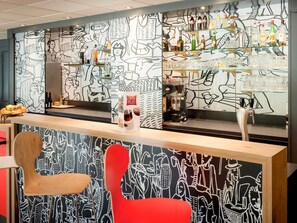 A bar area with a coffee machine, shelves with bottles, and a counter with a menu. - ibis Quimper (Quimper)