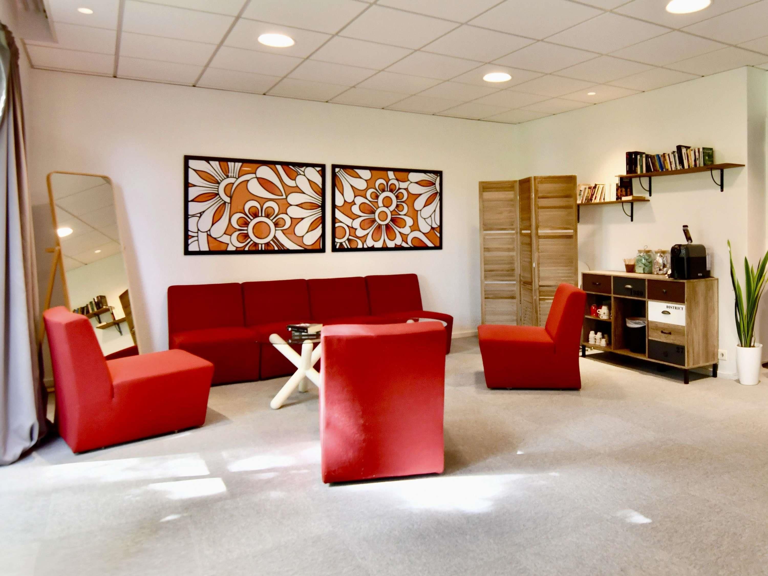 Ein modernes Wohnzimmer mit einem roten Sofagarnitur, einem Couchtisch und einem Bücherregal.